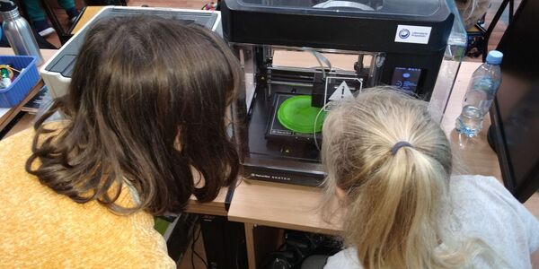 Druk 3D - uczennice obserwują proces drukowania
