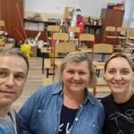 Rodzice w sali szkolnej - trzy osoby uśmiechnięte