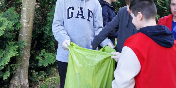 Uczniowie zbierają do worków śmieci