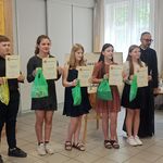 Uczestnicy na scenie z dyplomami i nagrodami