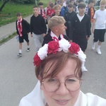 Pani Agata z biało-czerwonym wiankiem - w tle uczniowie