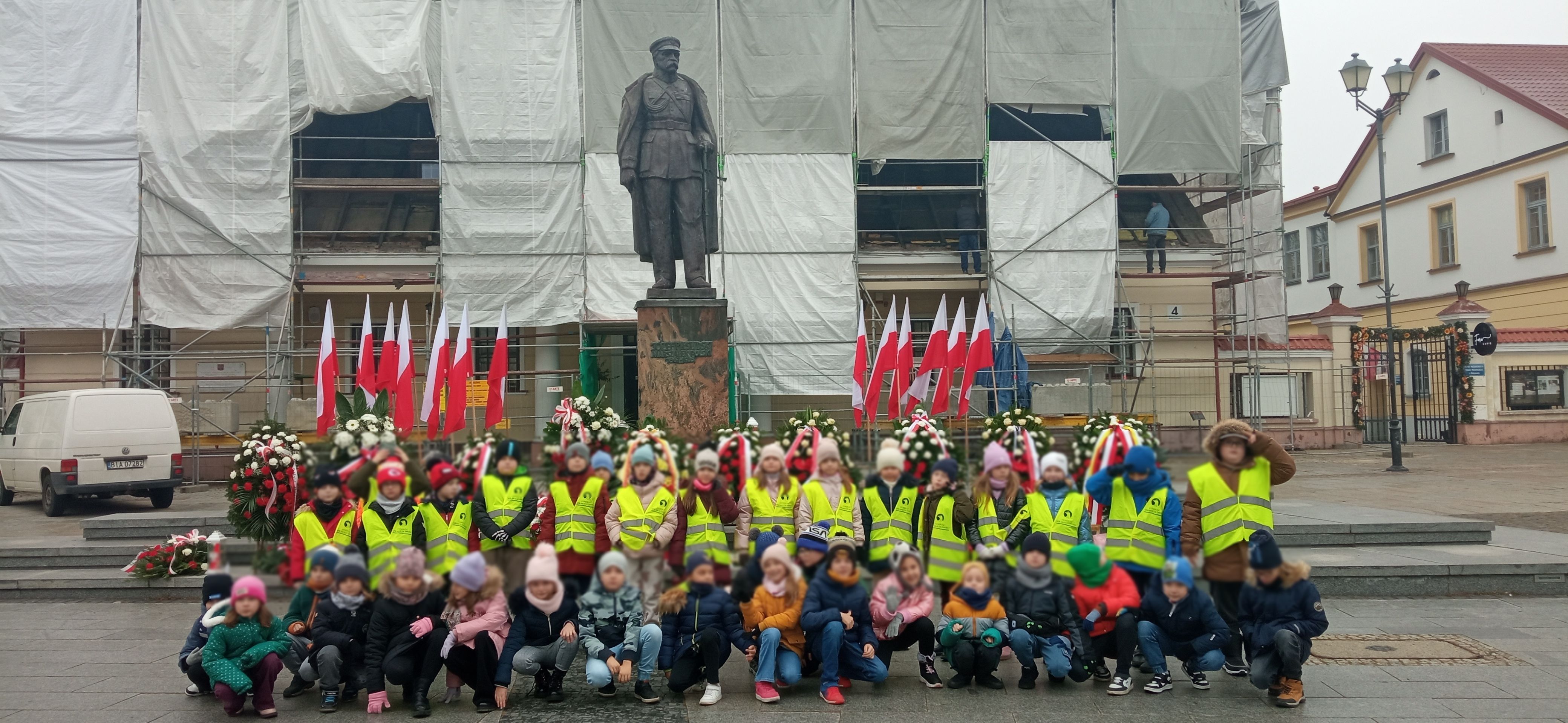 Uczniowie przed pomnikiem marszałka Piłsudskiego