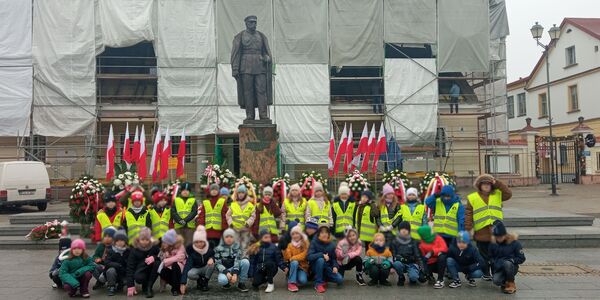 Uczniowie przed pomnikiem marszałka Piłsudskiego
