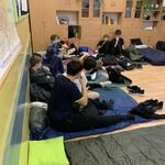 Uczniowie w sali na swoich materacach szykują się do snu