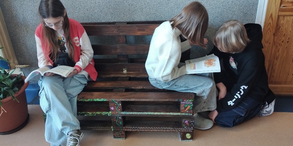 Uczennice na samodzielnie wykonanej ławeczce z palet