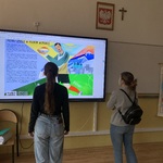 Uczniowie przed ekranem interaktywnym z tematyką projektową