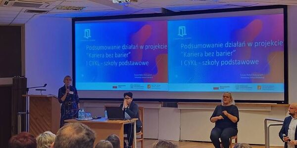 Konferencja - prowadzący na tle prezentacji