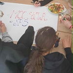 Uczniowie przygotowują plakat na tablicę 